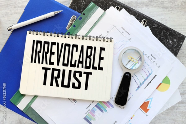 Fototapeta Irrevocable trust work desk blue folder blue financial charts. text on a notebook