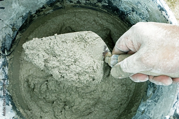 Obraz cement portland gray mix with spatula tool in bucket