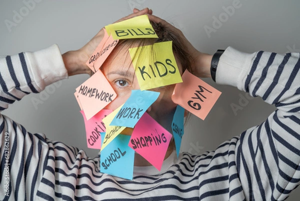 Fototapeta Mental load concept - female has post-it notes with social responcibilities on her face