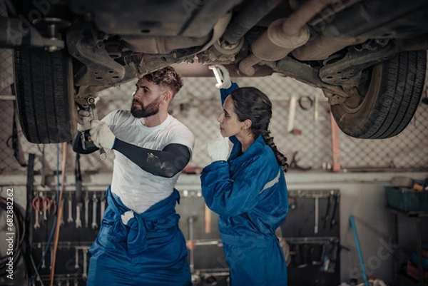 Fototapeta Auto mechanics diagnose suspension issues using precise tools, ensuring safe vehicle performance.