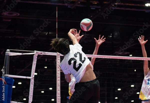 Obraz Volleyball outside hitter attacking against single block