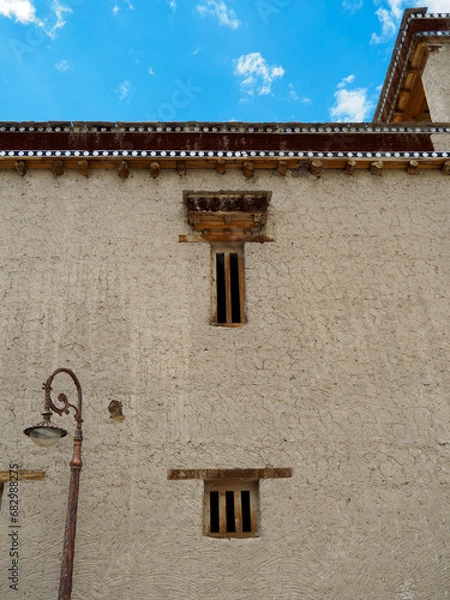 Obraz Outside wall of Shey Monastery Gompa, see cracks on stucco surface and old technique windows built. Eaves of the building is unique style, made and decorated with wood.