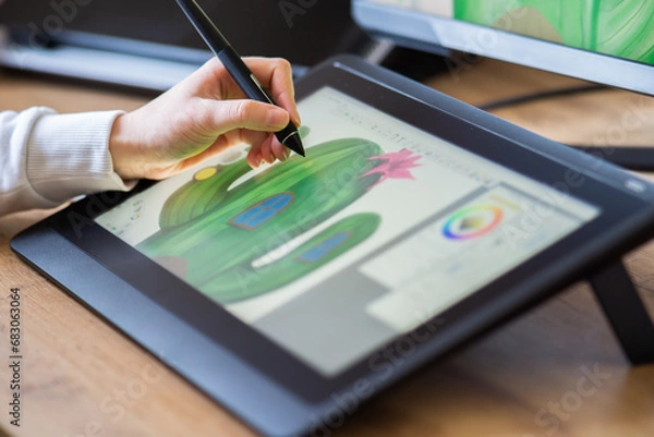 Fototapeta close up of a female hand drawing on a digital tablet. drawing on a digital drawing board. Graphic designer working from home