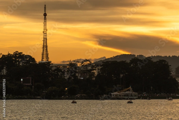 Fototapeta Sunset view of a Da Lat City with development buildings, transportation, market. Tourist city with center square of Da Lat city near Xuan Huong lake