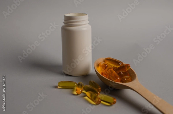 Fototapeta Omega-3 capsules lie in white bottle. Fish oil tablets. omega 6, 9, top view with copy space.