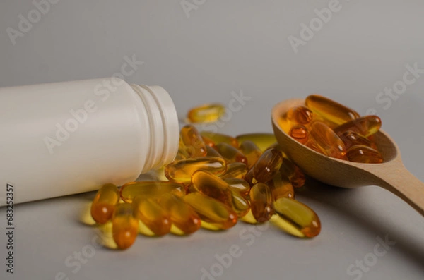 Fototapeta Omega-3 capsules lie in white bottle. Fish oil tablets. omega 6, 9, top view with copy space.