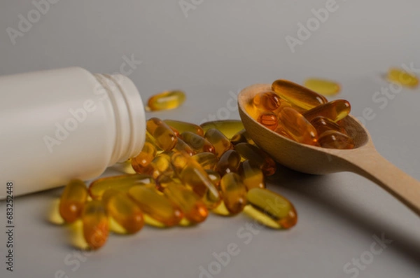Fototapeta Omega-3 capsules lie in white bottle. Fish oil tablets. omega 6, 9, top view with copy space.