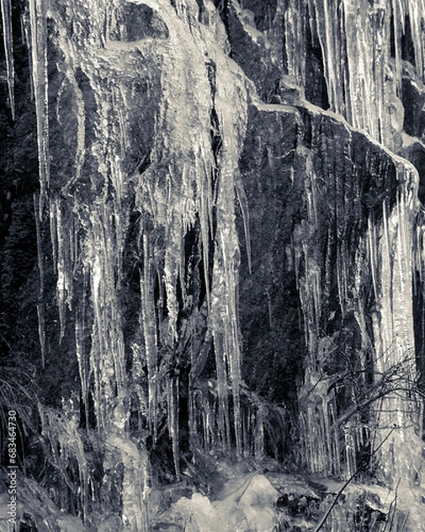 Obraz Frozen water fall on a granite rock face cliff in mid winter conveys cold, frigid, icy conditions