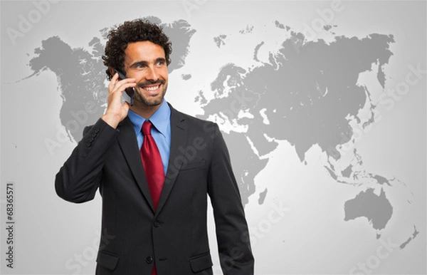 Fototapeta Man talking on the phone in front of a world map