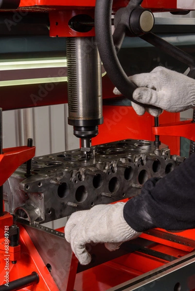 Obraz A master repairs an engine on a machine