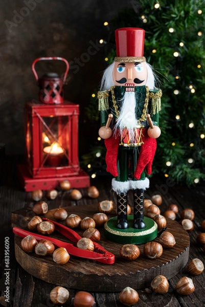 Obraz Festive Nutcracker soldier on Christmas background with hazelnuts