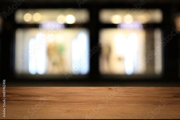 Fototapeta Beautiful empty wood table top counter, window view. Wooden table with blur bokeh background ready for product montage. Abstract blurred bokeh neutral background of city, shop, store, restaurant, city