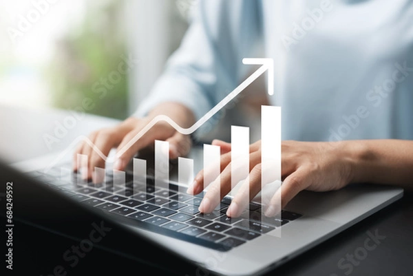 Fototapeta Businesswoman use laptop and tablet analyzing company growth, future business growth arrow graph, development to achieve goals, business outlook, financial data for long term investment.