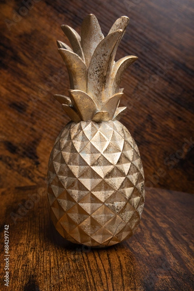 Obraz decorative pineapple, close-up of a decorative metal figure in the shape of a pineapple on a wooden background