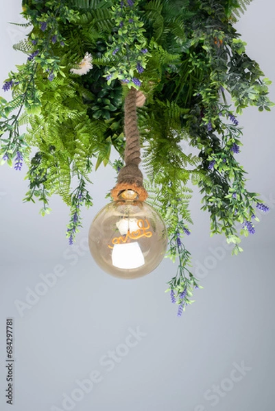 Obraz Hanging lamp made with hanging plant leaves and a large round bulb inside which we can see the word love