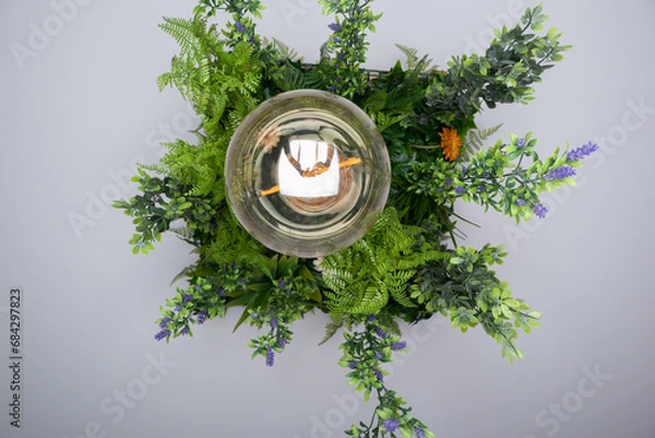 Obraz Hanging lamp made with hanging plant leaves and a large round bulb inside which we can see the word love