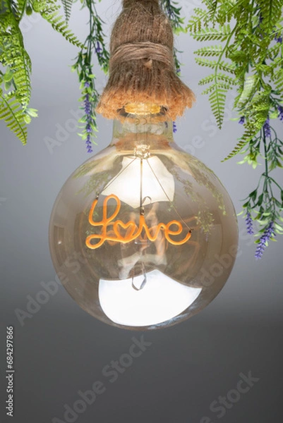 Obraz light bulb, closeup of a large round light bulb inside which you can see the word love