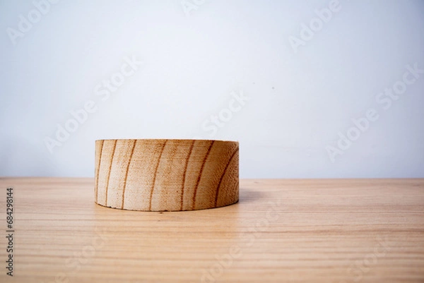Obraz wooden circular container on wooden surface, white background, horizontal photo