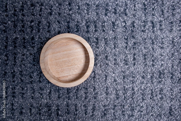 Obraz circular wooden bowl viewed from above on a gray carpet-like textured surface
