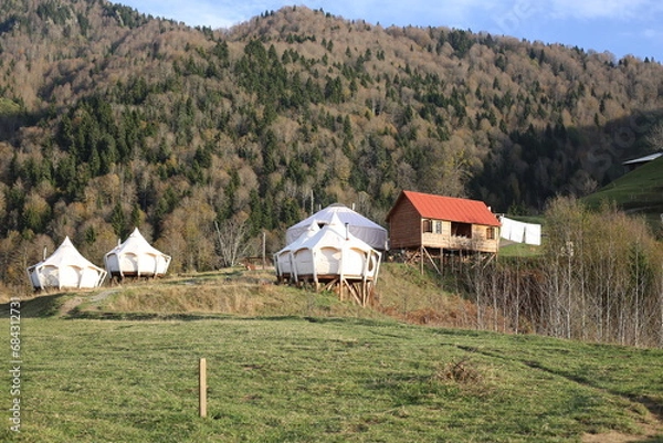 Obraz View of glamping tent on the nature in the beautiful countryside in the mountains in summer. White tent glamping camp. Luxury campsite.
