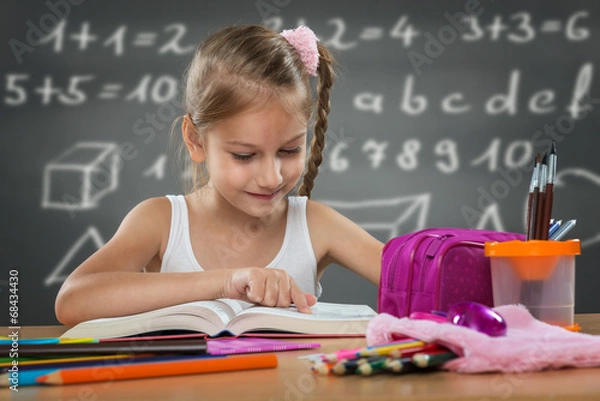 Fototapeta Little girl reading in school, written job behind the plate