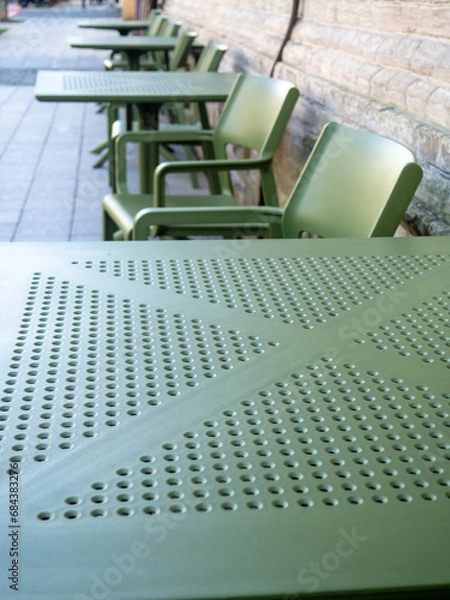 Fototapeta Empty plastic tables in a cafe. Green chairs and tables outside. The concept of no customers.