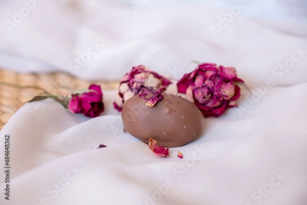 Obraz Chocolate pieces with flowers and roses on pink and white background also with mock up space