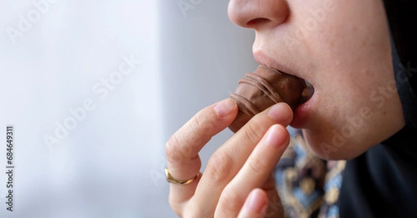 Fototapeta Close-Up Photo of a Woman's Mouth Savoring a Chocolate Delight with Ample Copy Space. Indulgence and Temptation Concept. Ideal for Dessert Enthusiasts and Sweet Treat Advertisements