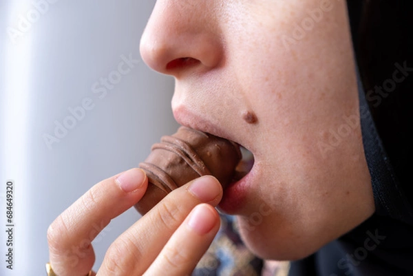 Fototapeta Close-Up Photo of a Woman's Mouth Savoring a Chocolate Delight with Ample Copy Space. Indulgence and Temptation Concept. Ideal for Dessert Enthusiasts and Sweet Treat Advertisements