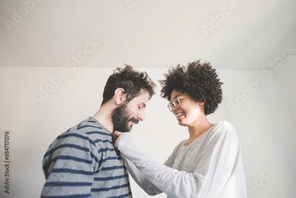 Fototapeta Young multiethnic couple having fun smiling together at home