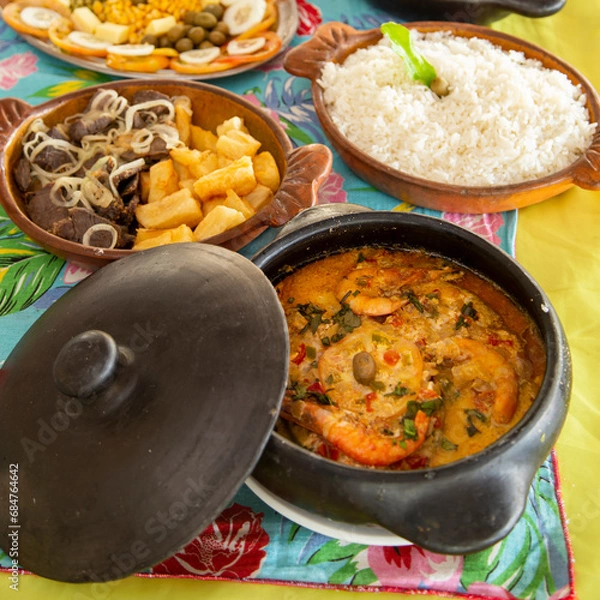 Fototapeta Pratos típicos nordestinos do Brasil, em panelas de barro com comidas variadas em uma mesa farta