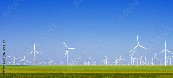 Fototapeta zielona łąka z turbinami wiatrowymi wytwarzającymi energię elektryczną