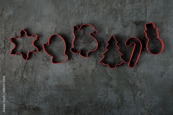 Fototapeta A row of red candy cutters on a concrete background. Christmas background. Advent time.  Natural modern Christmas background, banner. 
