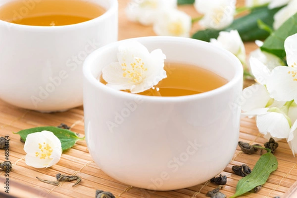 Fototapeta Green jasmine tea in white cups, selective focus