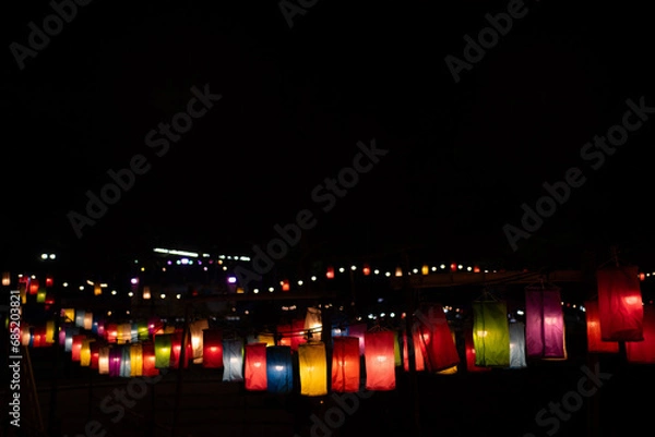 Fototapeta a paper lantern floats on a dark background.