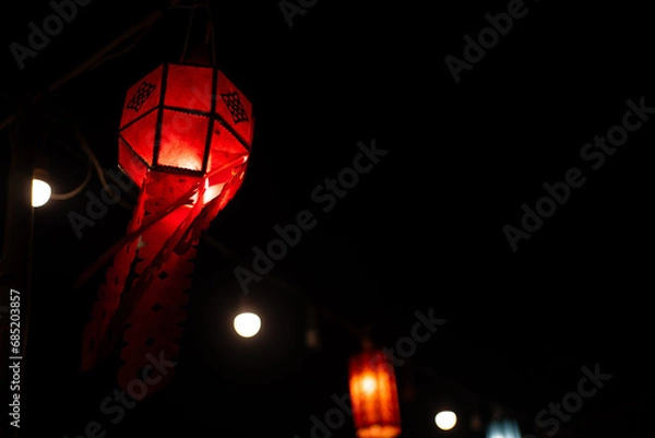 Fototapeta a paper lantern floats on a dark background.