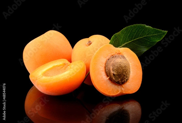 Obraz Three sliced apricots isolated on black