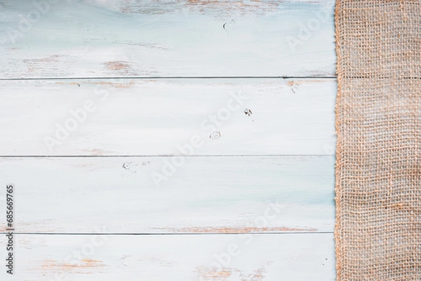 Fototapeta Table top view of bright blue and white wooden texture background with burlap banner. Image shot from overhead view.