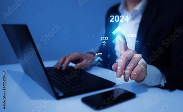 Fototapeta Businessman holding growth graph a year 2024 of business and data analysis. Development to success in year 2024.	