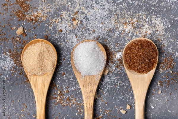 Fototapeta Various types of sugar in bamboo spoons, wholemeal, white and liquorice flavoured