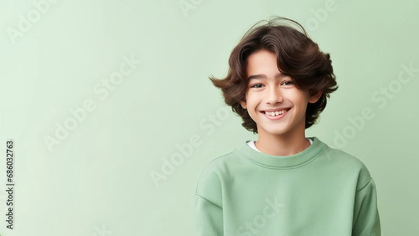 Fototapeta Happy Asian teen boy with brown hair wearing a green sweater