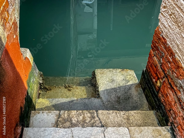 Obraz View of the steps for parking gondolas and boats leading into the water of the canal