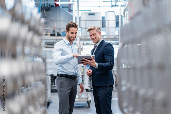 Fototapeta Two businessmen with tablet talking in a modern factory