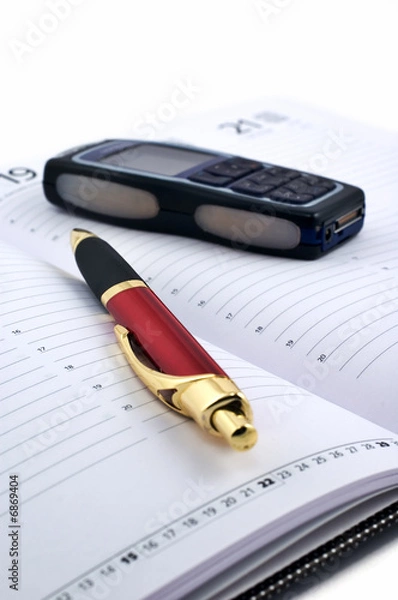 Fototapeta Pen and cell phone on open agenda