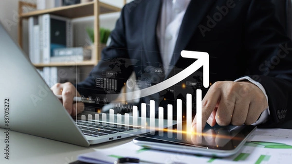 Fototapeta Increase revenue asset and profit.Businessman use laptop analyzing sustainability company growth with digital virtual graphics, financial data for long term investment..