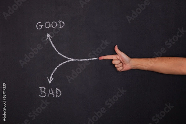 Fototapeta Hand pointing to a arrow that point to good or bad decisions