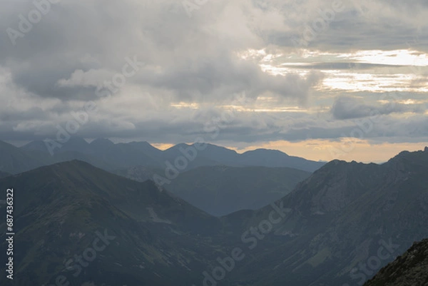 Fototapeta Mesmerizing mountain landscape high in the Polish Tatras at sunset through the clouds.