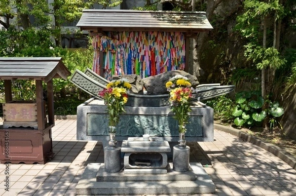 Fototapeta 大船観音寺境内に建立されている原爆犠牲者慰霊碑横の被爆石です。爆心地の西蓮寺からは地蔵尊の土台石、長崎の浦上天主堂からも石が寄贈されました。それぞれの被爆石は千羽鶴が刻まれた筏にのせられ、その台座には被爆者が平和の丘に向かう姿が描かれています。また、その慰霊碑の右手には原爆の火の塔があります。ぜひみなさまも恒久平和祈願にお参りくださいませ。