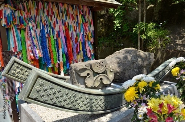 Fototapeta 大船観音寺境内に建立されている原爆犠牲者慰霊碑横の被爆石です。爆心地の西蓮寺からは地蔵尊の土台石、長崎の浦上天主堂からも石が寄贈されました。それぞれの被爆石は千羽鶴が刻まれた筏にのせられ、その台座には被爆者が平和の丘に向かう姿が描かれています。また、その慰霊碑の右手には原爆の火の塔があります。ぜひみなさまも恒久平和祈願にお参りくださいませ。