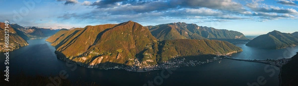 Fototapeta The sunset and the landscape seen from Mount San Salvatore at the end of an autumn day, near the town of Lugano, Ticino, Switzerland - 31 October 2023.